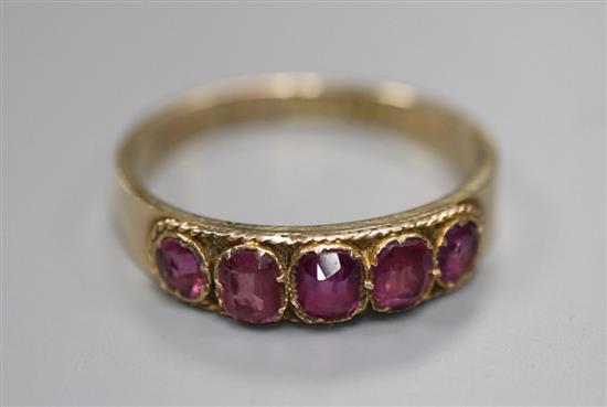 An early 20th century 10ct yellow metal and graduated five stone garnet set half hoop ring, size R, gross 1.9 grams.